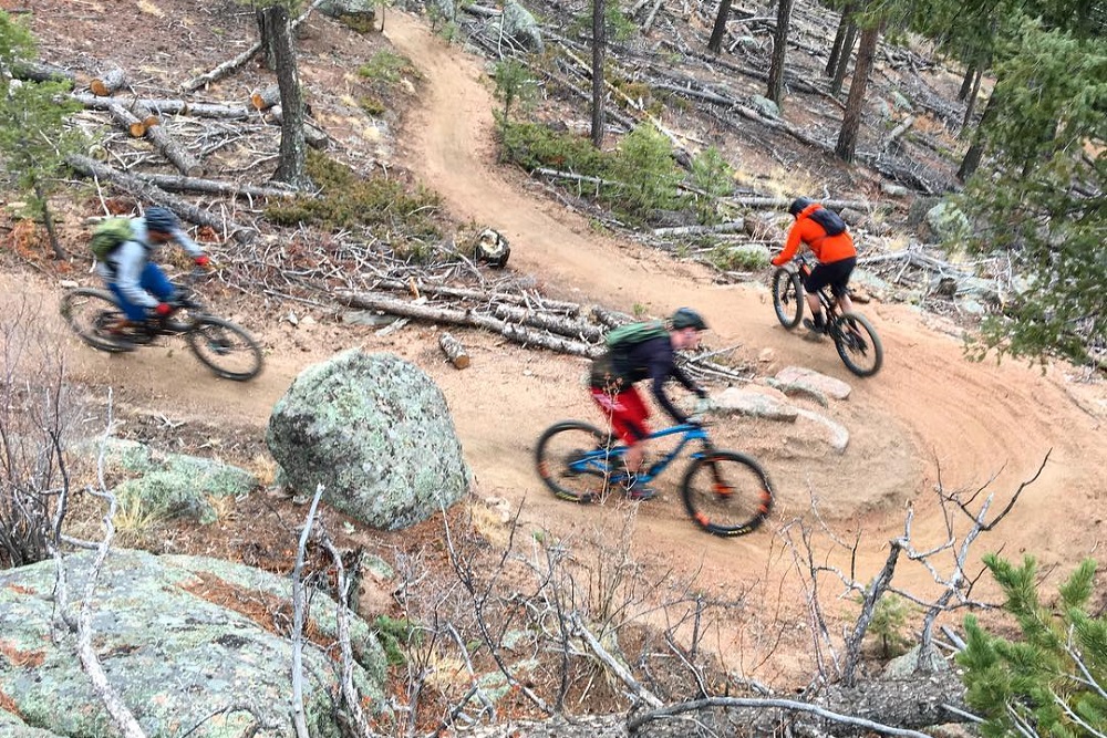 mountain bikers riding through switchbacks