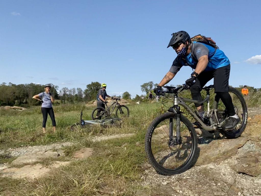 A man in blue shirt riding during a skills clinic