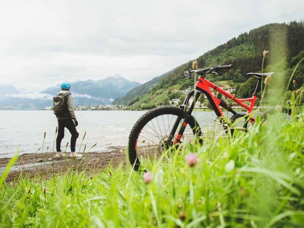 mountain biker looking at a lake wearing a backpack
